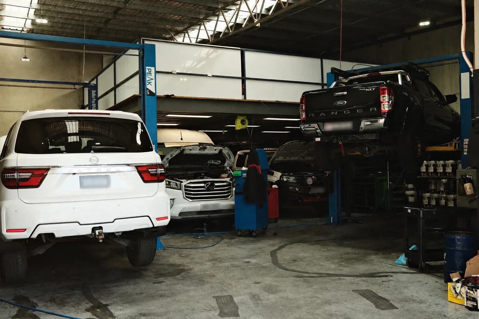 Inside the Rev'd Up Mechanical workshop in Smeaton Grange, with vehicles up on the hoists mid-service